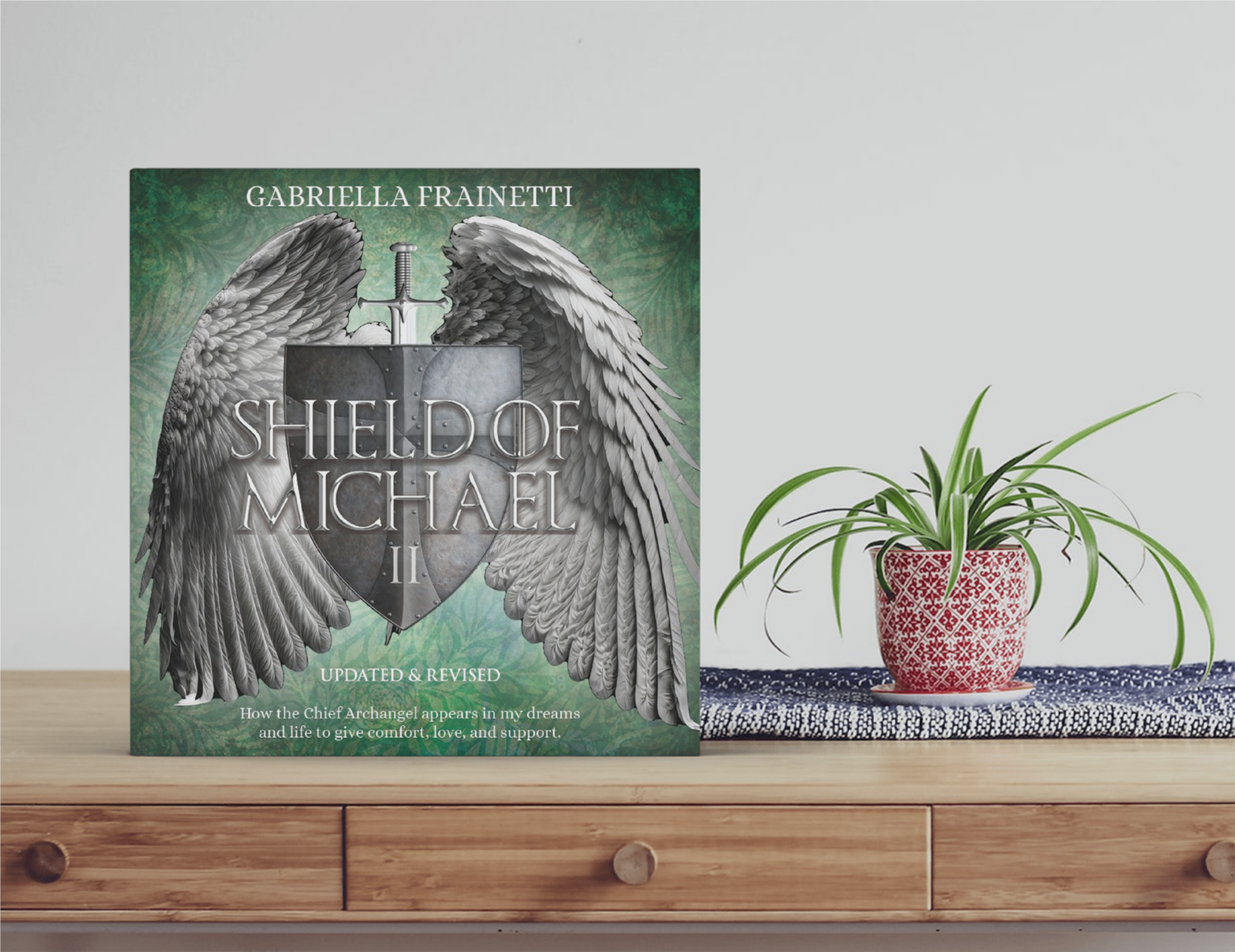 Square green book on a table next to a potted plant